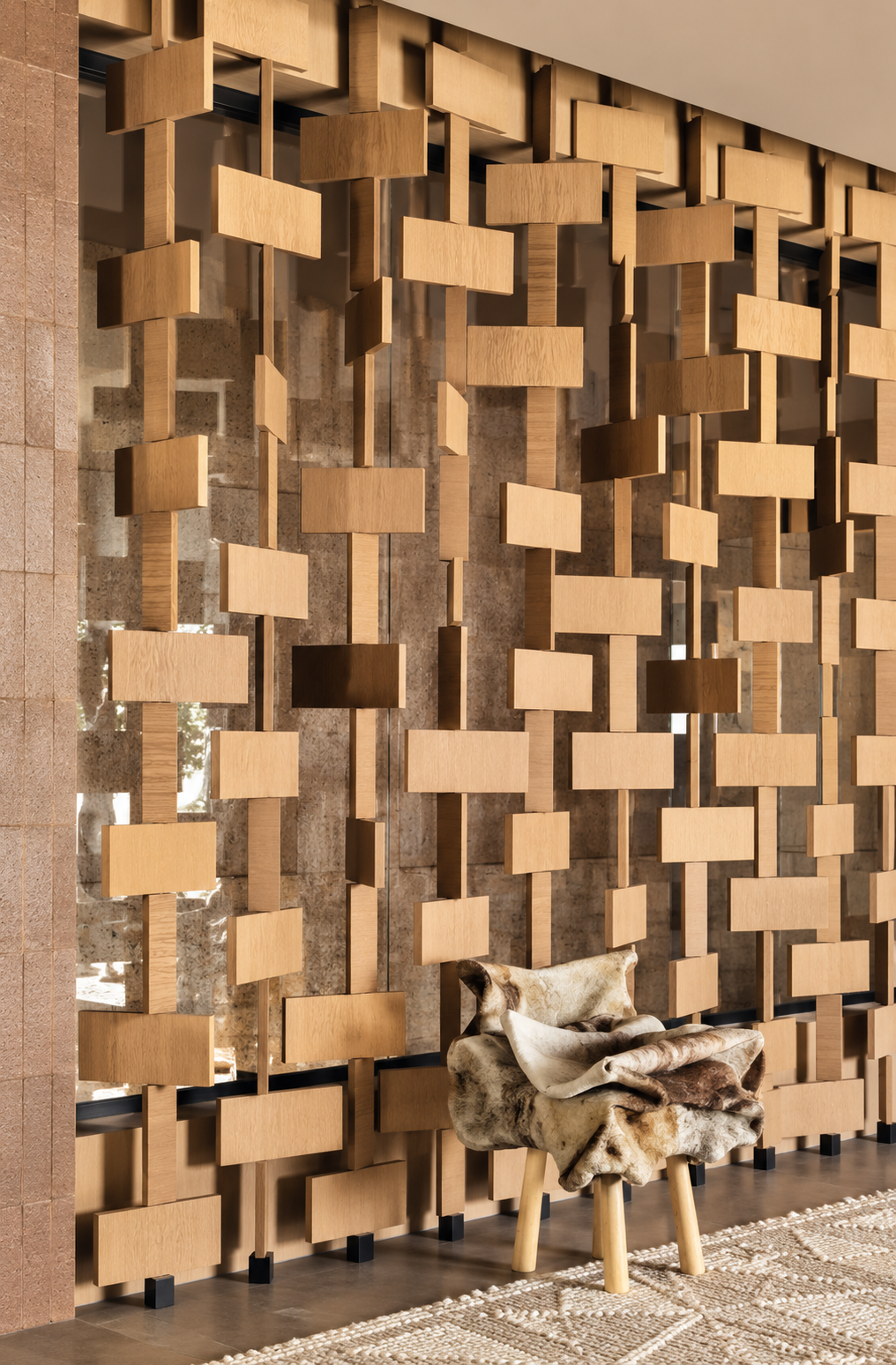 Muro decorativo de módulos de madera suspendidos con silla tapizada en piel