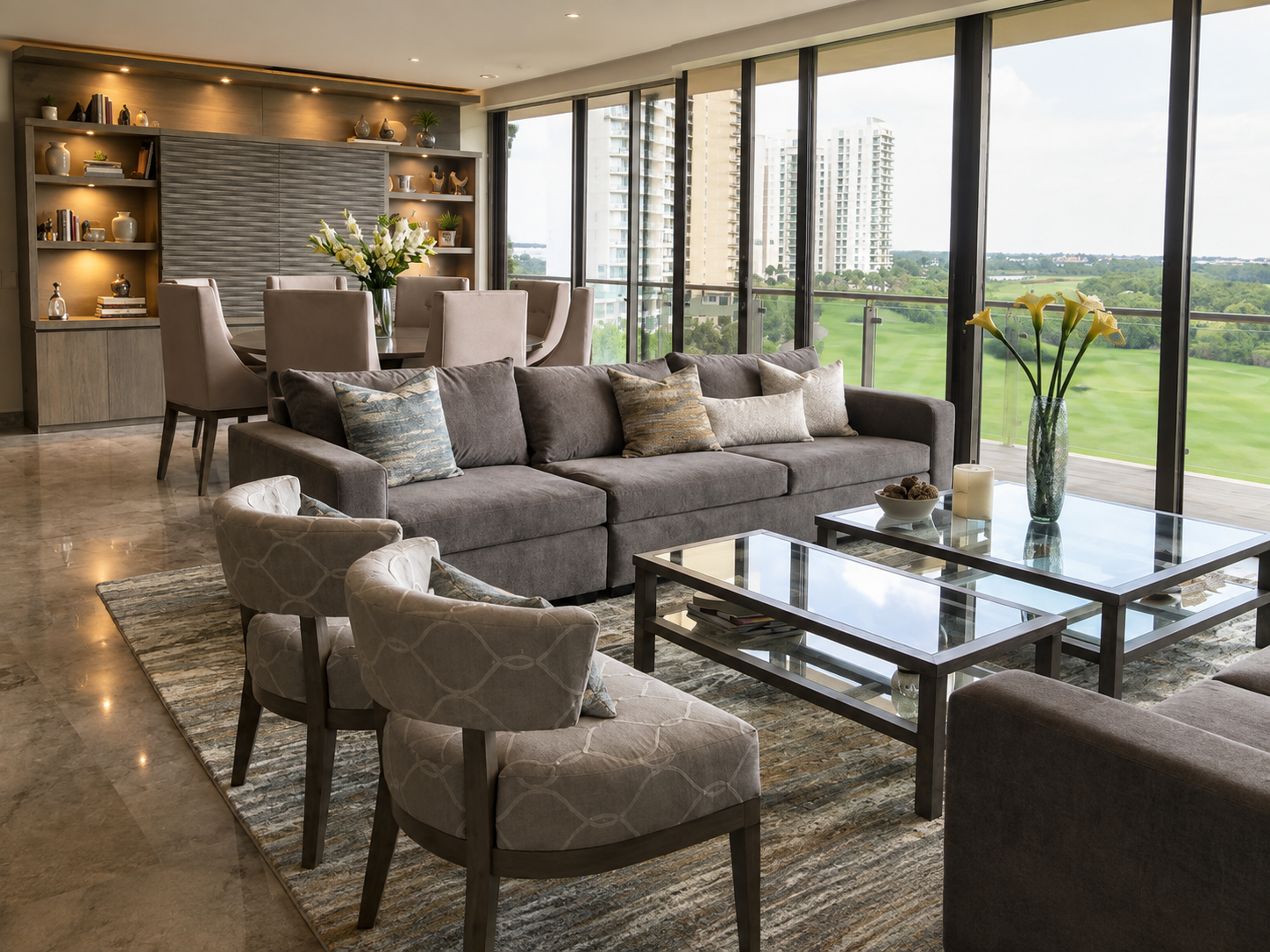 Sala urbana con sofá seccional gris, sillones capitonados, mesas de centro de cristal y vista a campo de golf
