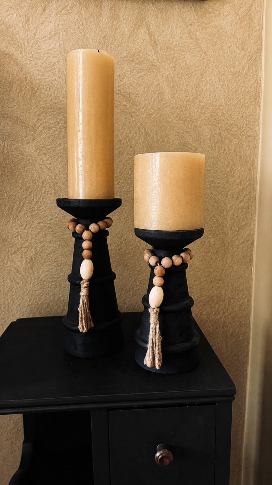 Par de candeleros de madera negra con cuentas de madera y velas color miel