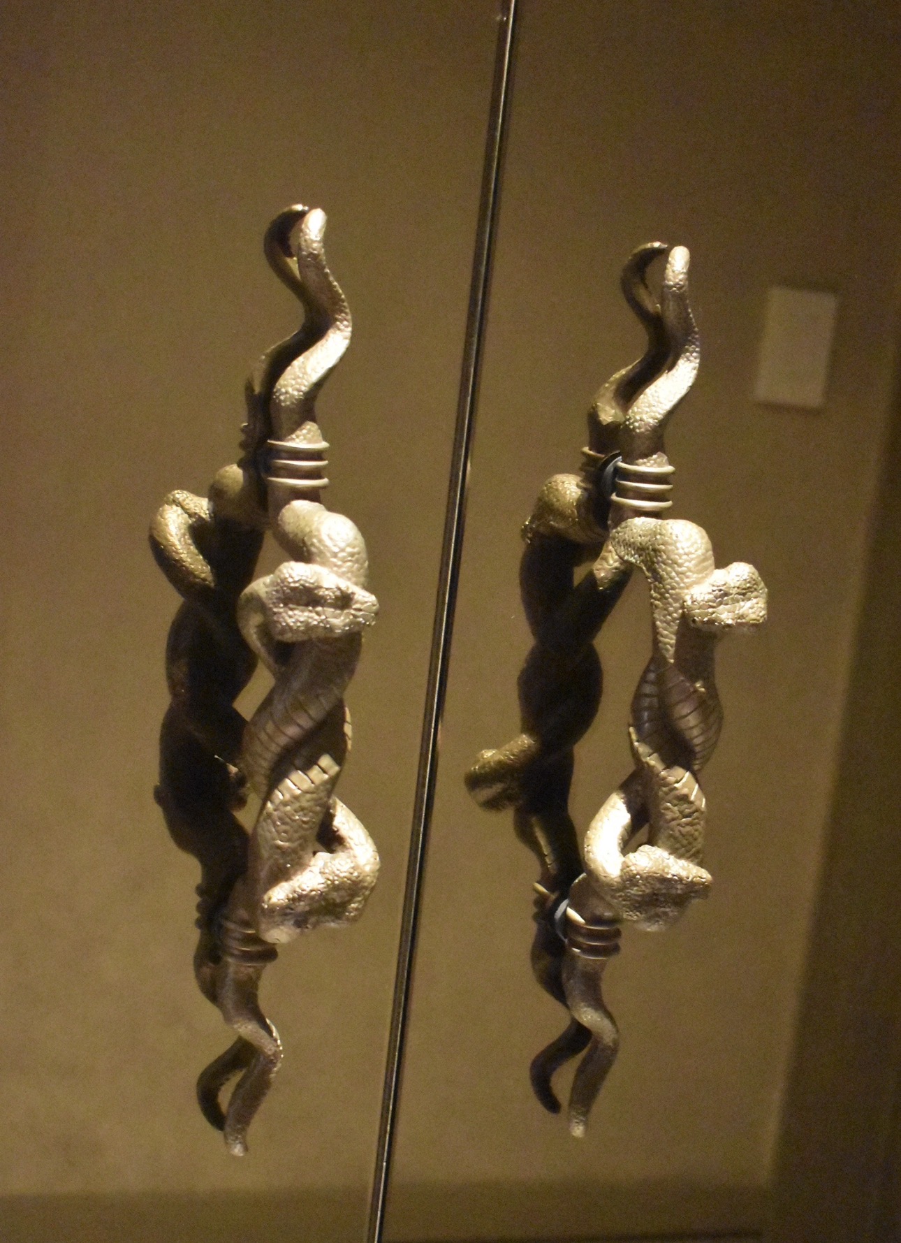 Tirador de puerta escultórico en bronce con forma de serpiente enrollada